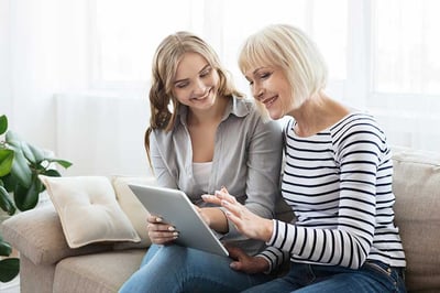 daughter-teaching-senior-mother-to-use-tablet-computer