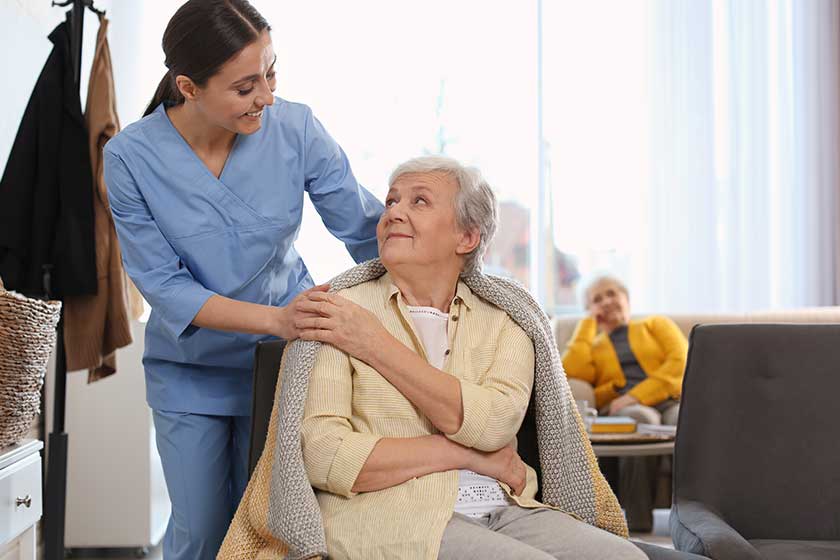 Nurse taking care of elderly woman in geriatric hospice